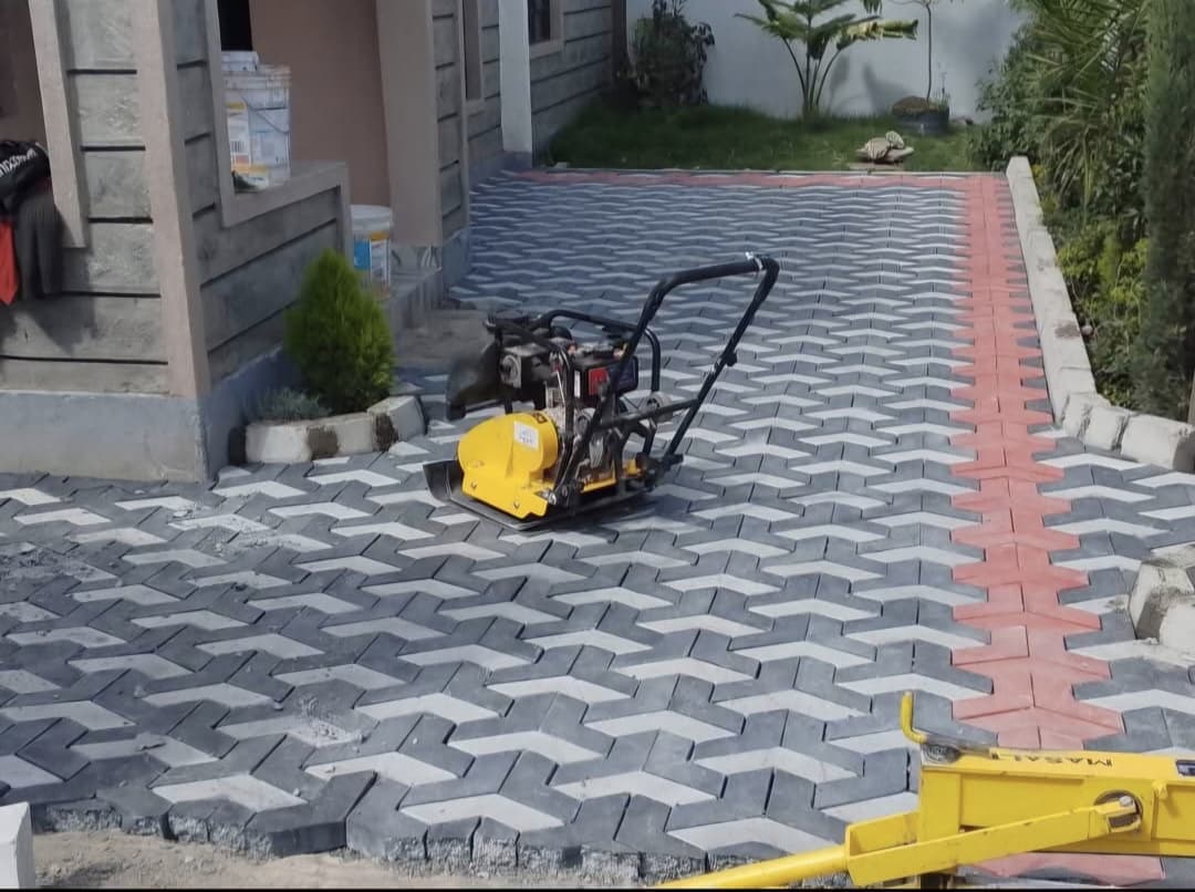 Plate compactor finishing a trihex cabro driveway during installation